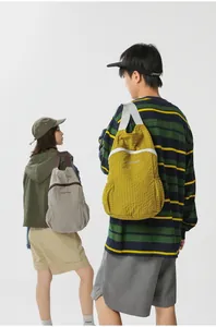 Rear view of models with foldable grid pattern backpacks for hiking and travel