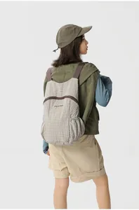 Back view of a woman wearing a lightweight foldable checkered outdoor backpack for travel