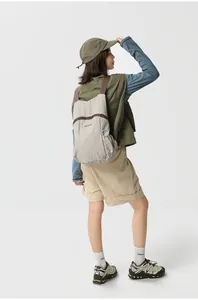 Detailed back view of an Asian model wearing a foldable lightweight beige hiking backpack
