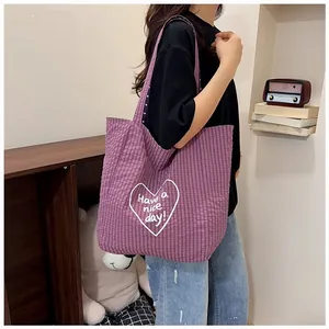 Close-up detail of purple checkered canvas tote bag featuring heart 'Have a nice day' print