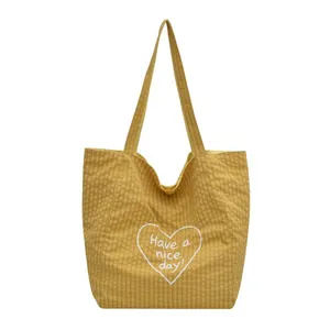 Yellow gingham canvas tote bag for women featuring white heart print and Have a nice day slogan
