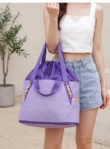 Detailansicht einer großen lila leichten Reisetasche, die von einem Modell getragen wird