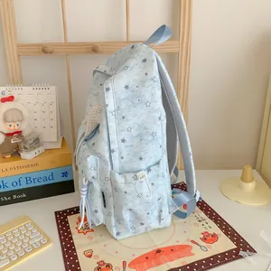 Side view of light blue backpack with star patterns on a styled desk