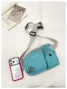 Close-up detail of a blue nylon crossbody bag with adjustable gray strap