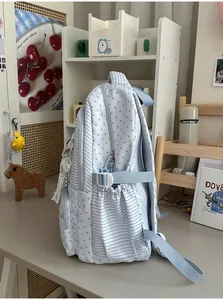 Side detail of a cute light blue student backpack with star and stripe patterns.