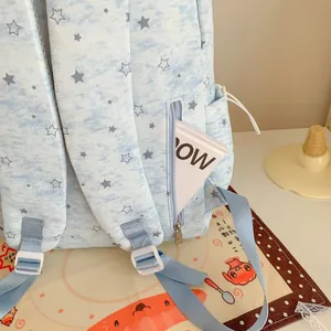 Close-up of a blue backpack with white star patterns showing a side zipper pocket.