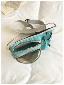 Detailed view of the internal zippered compartments of the teal Korean crossbody bag.