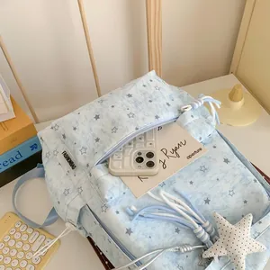 Detailed macro view of light blue star print backpack featuring front pocket and star charm
