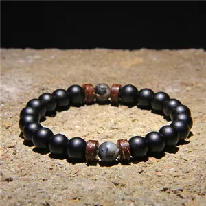 Macro view of men's matte black volcanic stone bracelet with natural wood spacers and beads