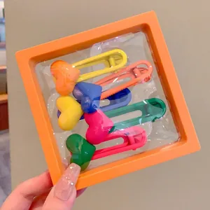 Detail view of orange PE film suspension box storing colorful heart hair clips.