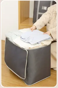 Detailansicht einer großen grauen Oxford-Stofftasche beim Einpacken von Kleidung