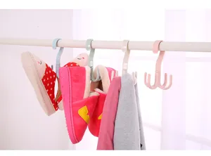 Detail showing rotating four-claw hooks hanging slippers and scarves on a closet rod.