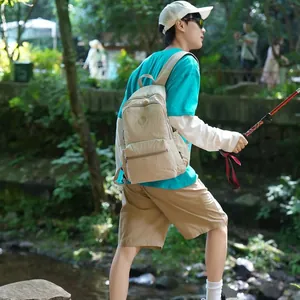 Outdoor lifestyle shot of a beige lightweight nylon backpack for hiking and travel
