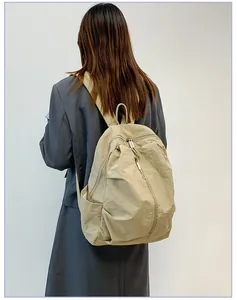 Vue de dos d'un sac à dos en nylon beige imperméable pour voyageur, grande capacité