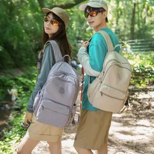 Two models wearing lavender and cream lightweight outdoor backpacks in a forest