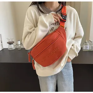 Close-up of a vibrant orange sport crossbody chest bag worn by a model