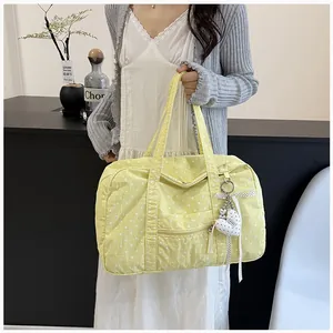 Yellow polka dot Boston bag for women, large capacity travel tote held by a model