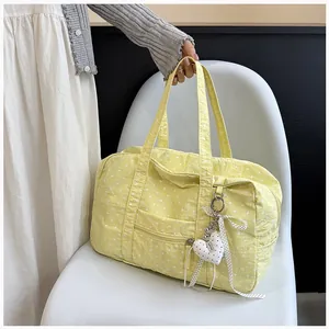 Close-up of a yellow polka dot Boston bag with a cute heart pendant decoration