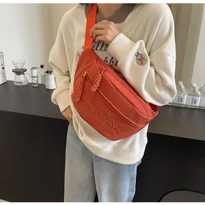 Sporty orange crossbody chest bag with adjustable strap and braided zipper details
