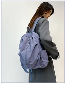 Vue détaillée d'un sac à dos en nylon violet imperméable porté par un modèle