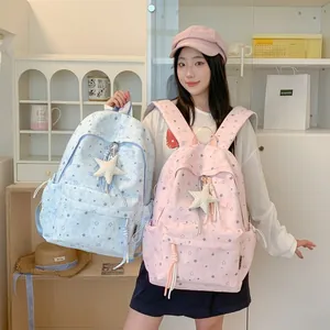 Close-up of pink and blue star pattern backpacks worn by a student girl for school.