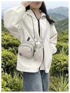 Off-white nylon crossbody bag with water bottle holder shown on outdoor model