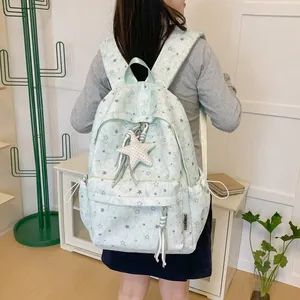 Detailed back view of a mint green star pattern backpack with star pendant for travel and school