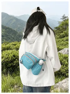 Back view of a girl wearing a light blue crossbody bag with water bottle holder outdoor.