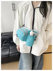 Close-up of a blue crossbody bag with a water bottle holder on a model.