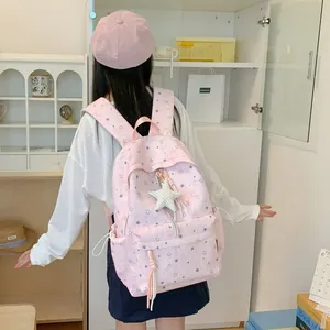 Pink Korean-style star pattern backpack for girls shown in a lifestyle indoor setting
