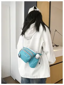 Detail view of a light blue Korean style crossbody bag worn by a model in a white jacket