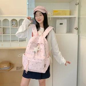Korean style pink backpack with star patterns and pendant worn by model in room