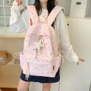 Close-up detail of a pink star pattern backpack featuring a cute star charm and tassels.
