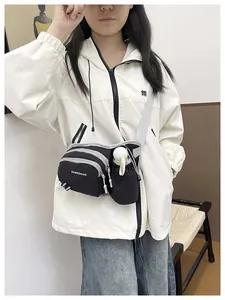 Functional black crossbody bag with water bottle holder shown on a white jacket detail view