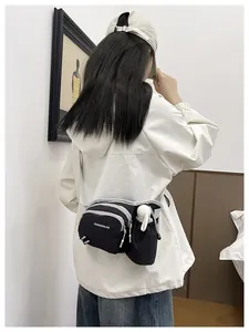 Detailed back view of a black nylon messenger bag featuring a side water bottle pocket