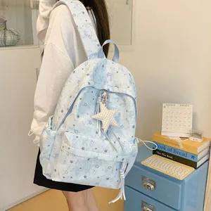 Detailed side view of a light blue star-patterned backpack worn by a student