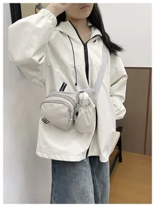 Detail view of a white minimalist crossbody bag with water bottle holder on a model