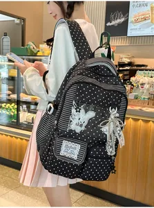 Close-up of a Japanese style black backpack featuring star patterns and a lace bow