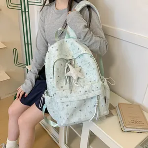 Girl wearing a mint green star pattern backpack in a minimalist room setting