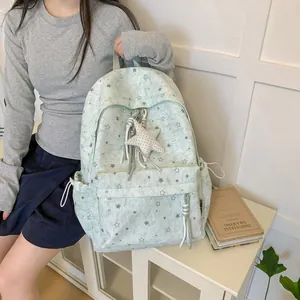 Stylish mint green backpack with star pattern worn by model in a cozy indoor setting