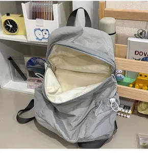 Detailed interior view of a grey lightweight student backpack with multiple compartments