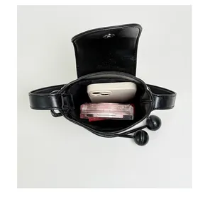 Top view showing interior capacity of minimalist black bucket phone bag with drawstring.