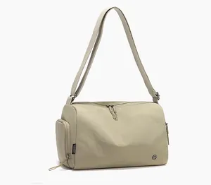 Detail of minimalist beige sports bag with double zippers and long shoulder strap