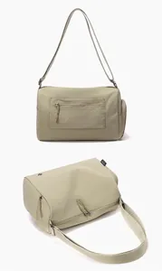 Detail view of beige sports gym bag showing zipper pockets and adjustable shoulder strap.