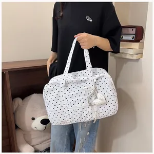 Large capacity white polka dot Boston travel tote bag with heart pendant held by model