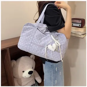 Purple polka dot Boston bag shown on a model's shoulder in a cozy lifestyle setting