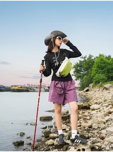 Weibliches Model trägt eine grün-weiße, wasserabweisende Outdoor-Sport-Brusttasche