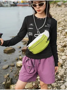 Asiatisches Model mit einer grün-weißen wasserdichten Outdoor-Sport-Brusttasche.