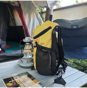 Mochila de senderismo amarilla de ripstop con linterna y tienda en un entorno natural