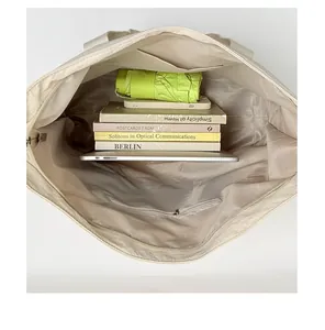 Große beige Tragetasche Innenansicht mit Büchern und Tablet für den täglichen Weg